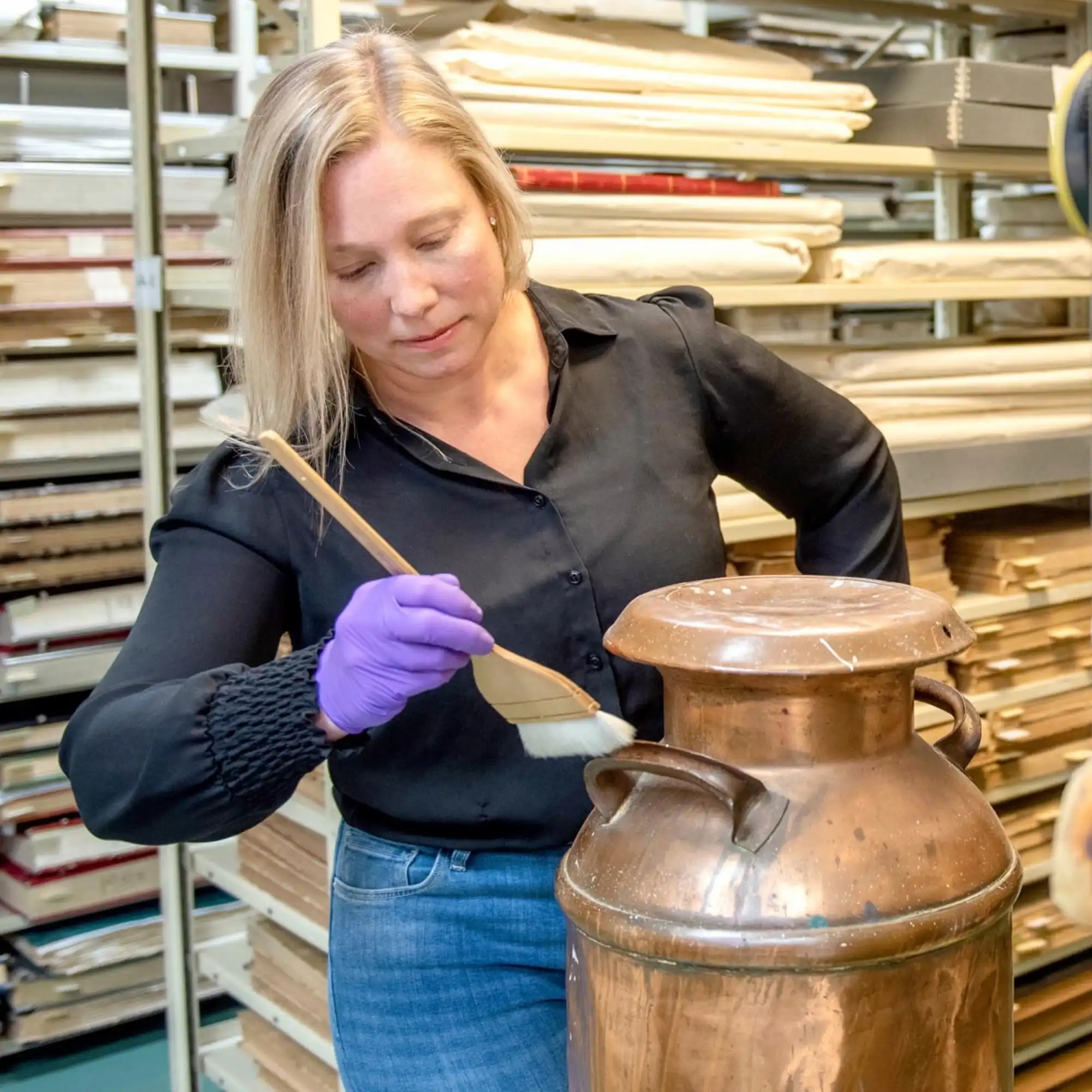 NCAM staff cleans artefact with brush