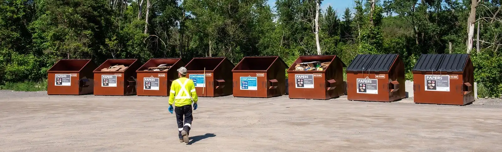 County staff walks in front of bins at Community Recycling Centre