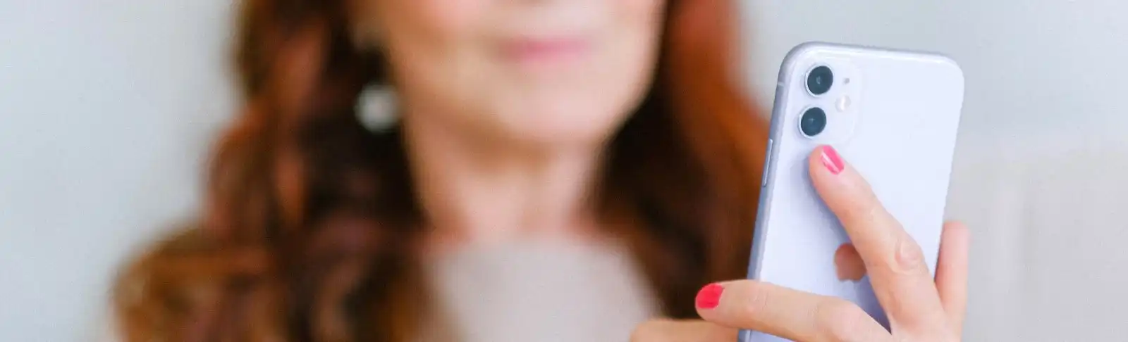 woman looks at phone screen