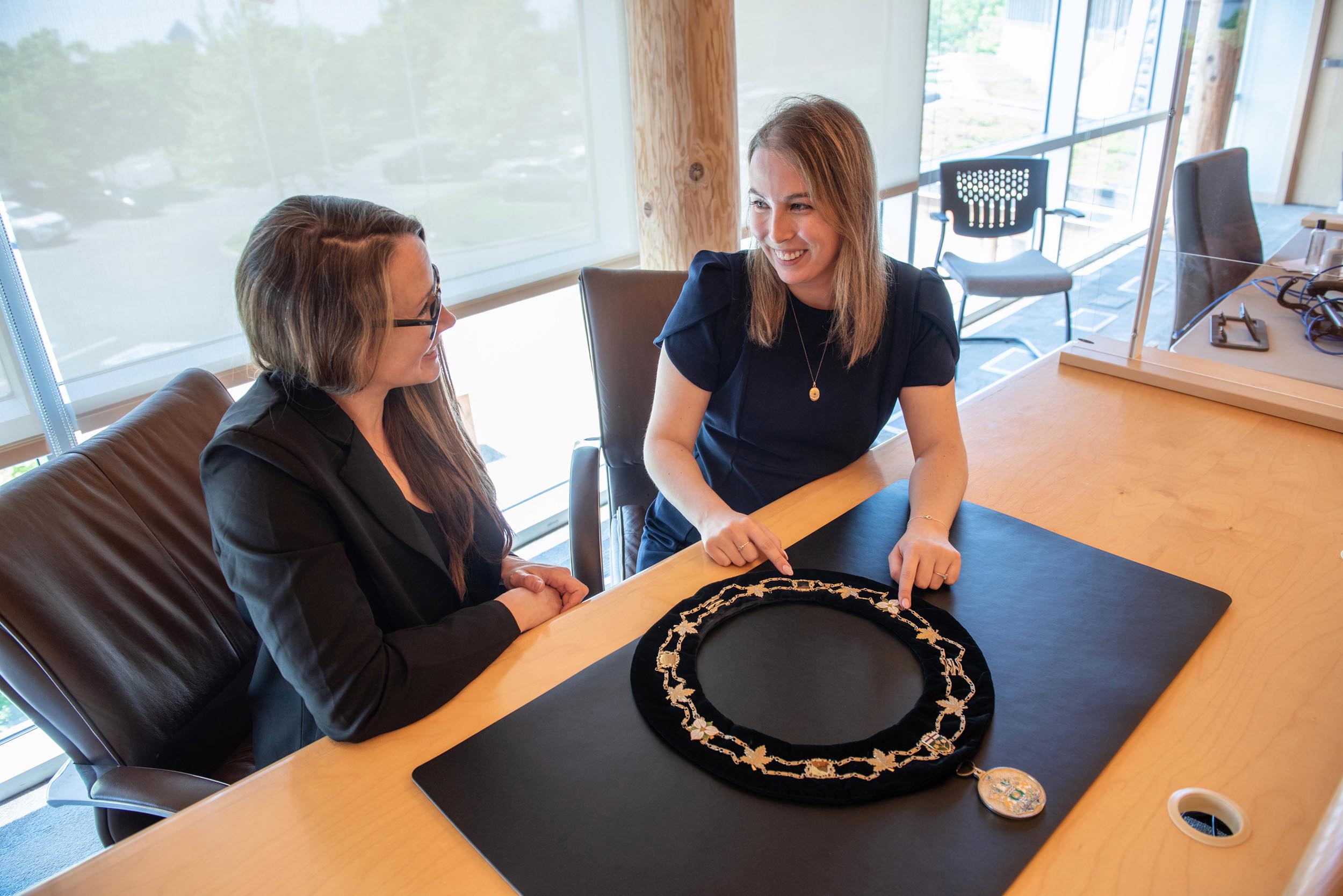 Clerk and Deputy Clerk sit behind desk with Warden's chain on it
