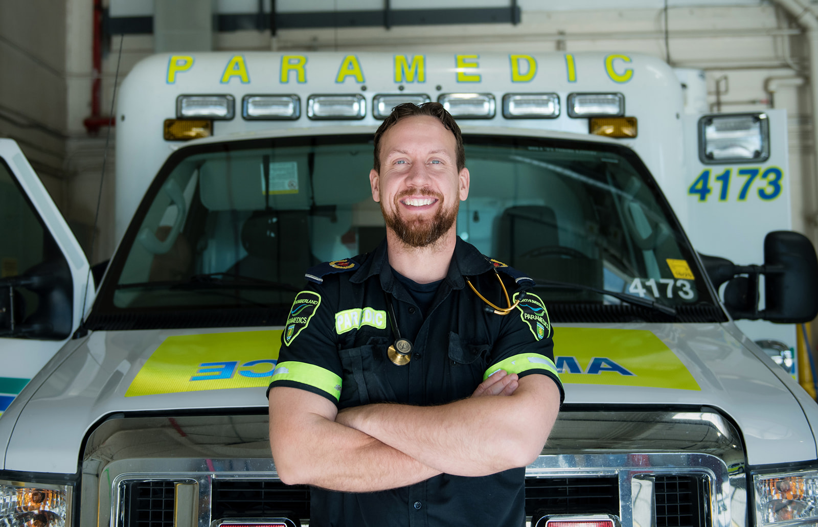 Northumberland Paramedic smiles in front of ambulance