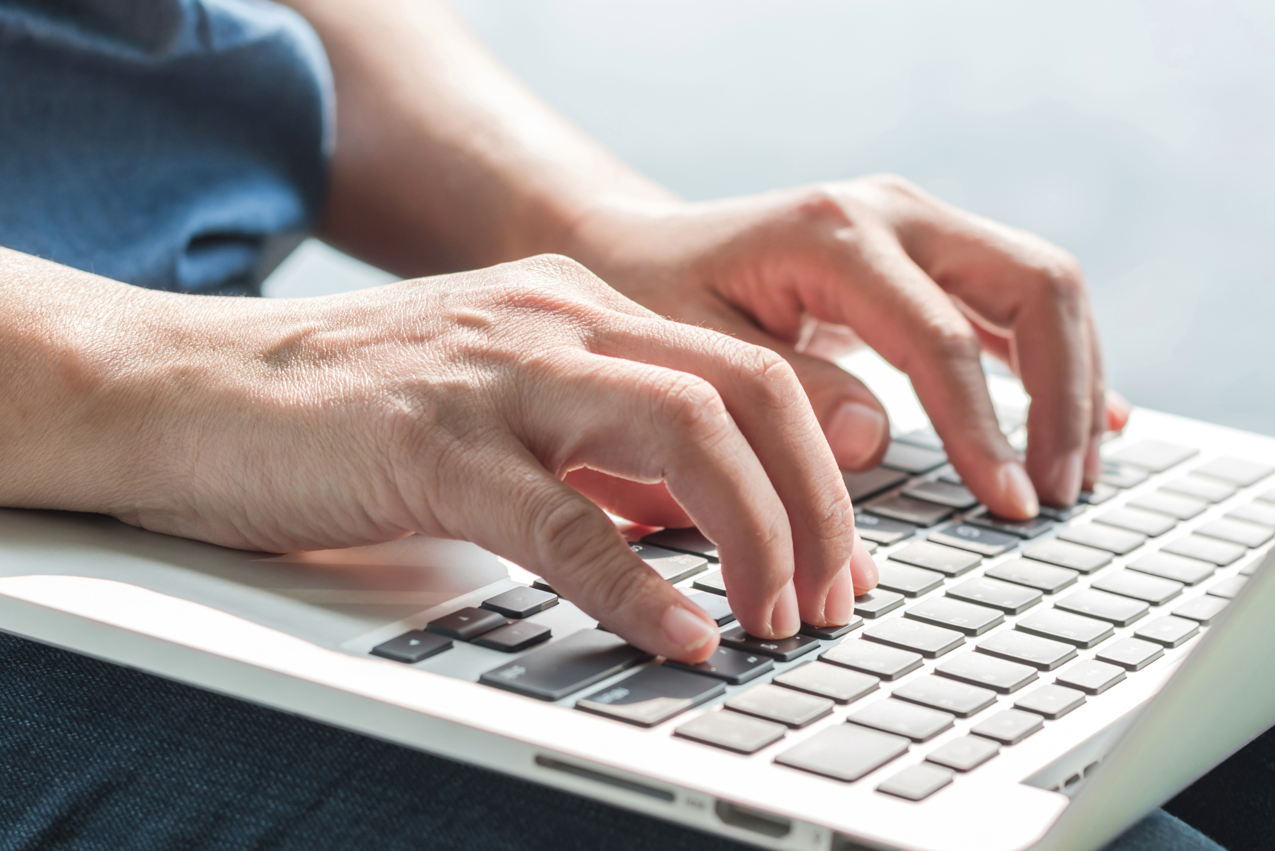 Hands typing on a keyboard.