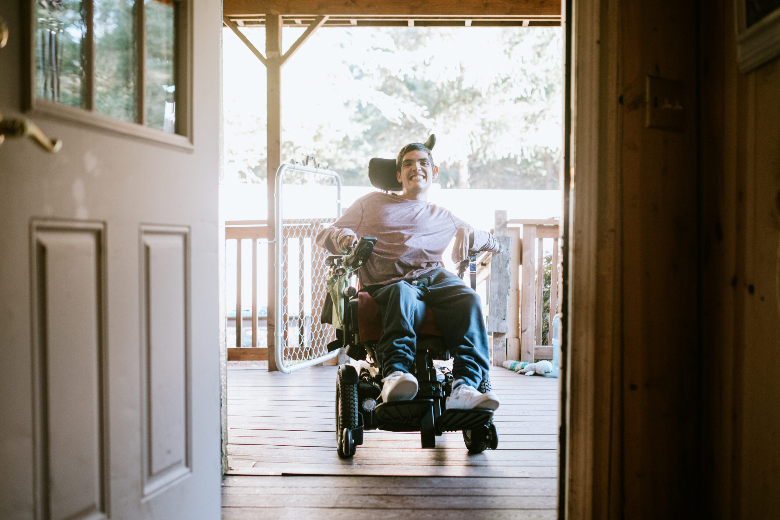 Man in wheelchair smiles as he enters his home